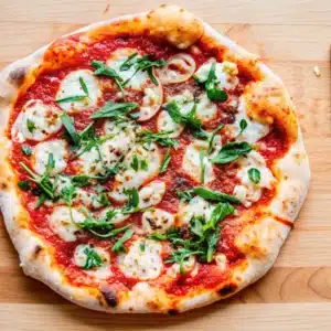 Classic Margherita Pizza on rustic wooden table with fresh basil and mozzarella